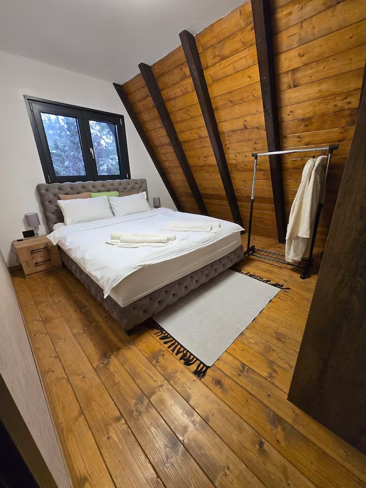 Second bedroom with warm wood-paneled walls