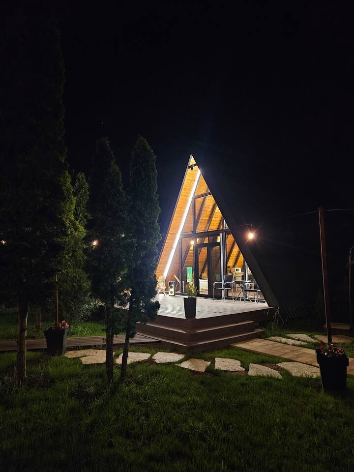 A-frame cabin lit up on a cold winter night